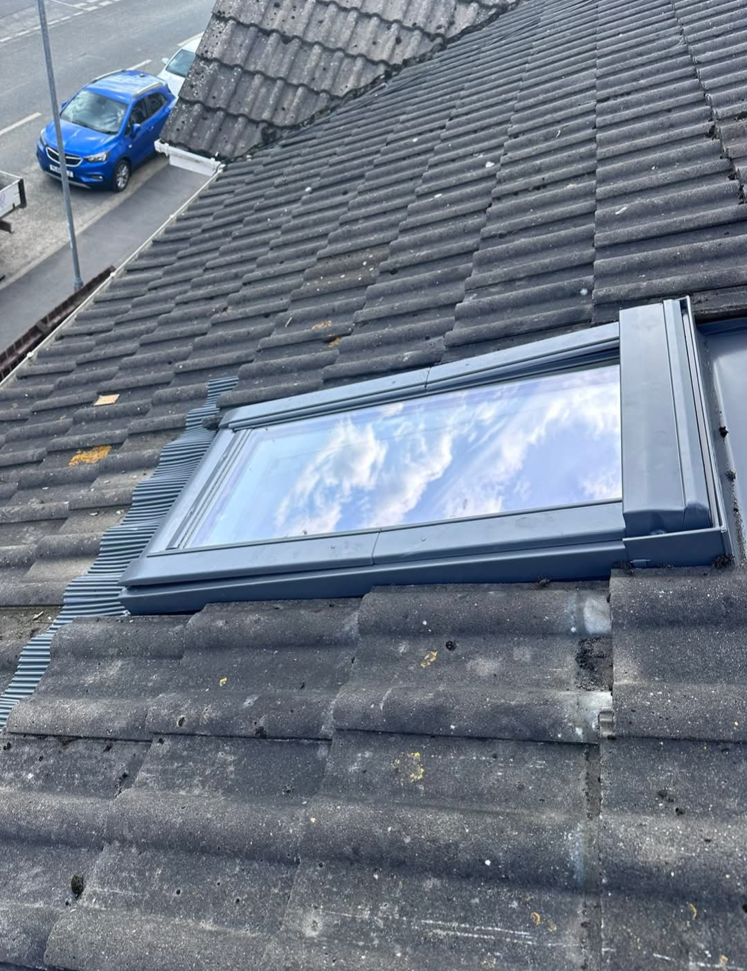 Velux roof window fitted into a tiled roof with flashing around the frame.
